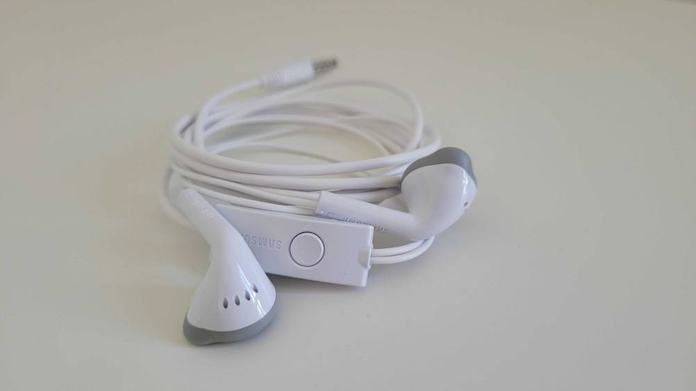 Im Test: Nahaufnahme der zusammengerollten Samsung-In-Ear-Kopfhörer auf einer hellen Fläche.