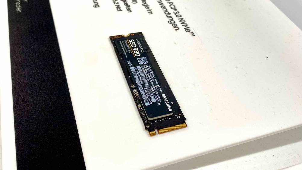 Im Test: Eine M.2-SSD von schräg seitlich in eine weiße Informtionstafel eingebettet.