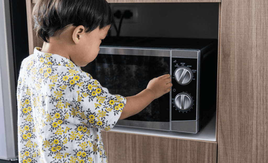 Samsung-Mikrowelle-Test: Ein kleiner Junge bedient eine Mikrowelle. 