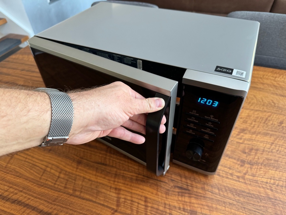 Eine Hand öffnet die Tür der Samsung MW3500K