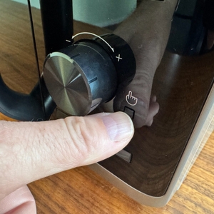 Eine Hand drückt einen Knopf auf der Samsung MW3500K