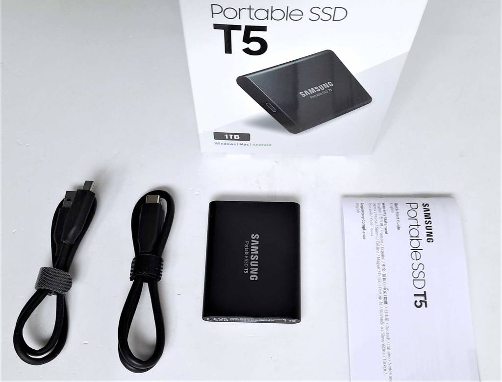 Externe SSD-Festplatten im Test: ein schwarzes Modell der Marke Samsung liegt neben dem Zubehör vor der weißen Originalverpackung.