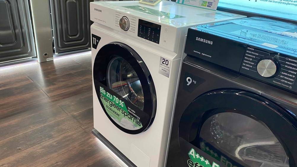 Eine getestete Samsung-Waschmaschine neben anderen Produkten in einer Ausstellung.