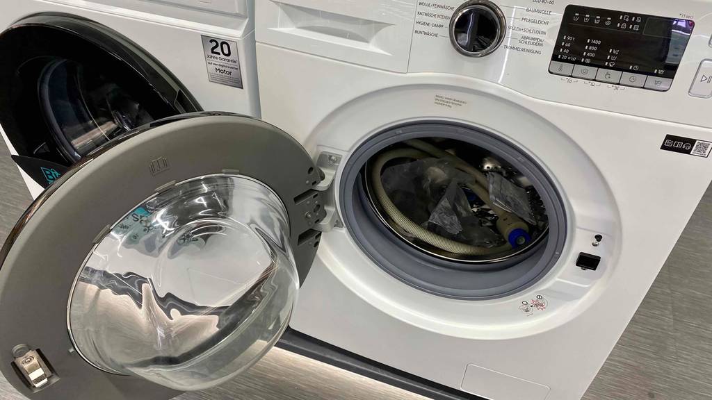 Im Test: Samsung Waschmaschine mit geöffneter Tür steht auf Sockel neben anderer.