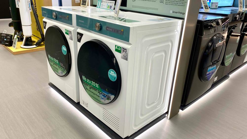 Ein Samsung-Waschtrockner im Test neben anderen Produkten in einer Ausstellungsfläche.
