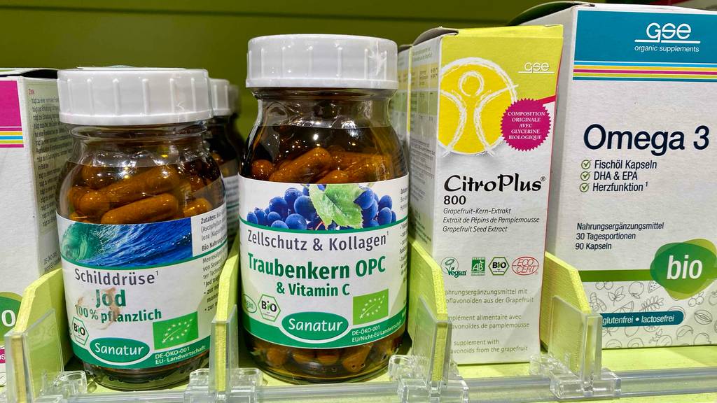 OPC-Test: Traubenkernextrakt-Kapseln der Marke Sanatur befinden sich in einer Braunglas-Flasche mit weißem Drehverschluss zwischen weiteren Nahrungsergänzungsmitteln im Verkauf.