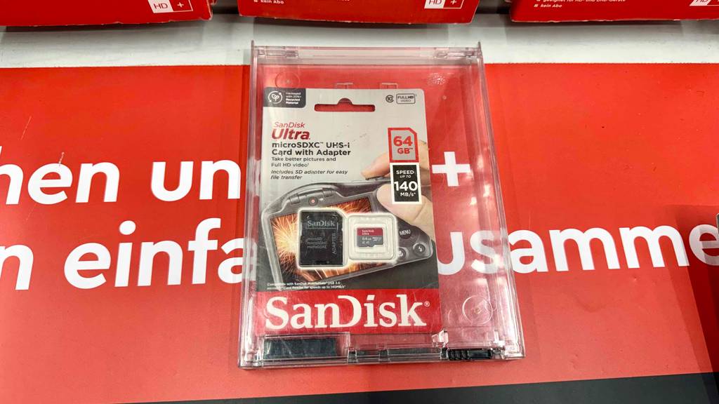 Getestet: Eine Micro SD-64 GB-Karte von SanDisk liegt in ihrer Verpackung auf einer roten Oberfläche.