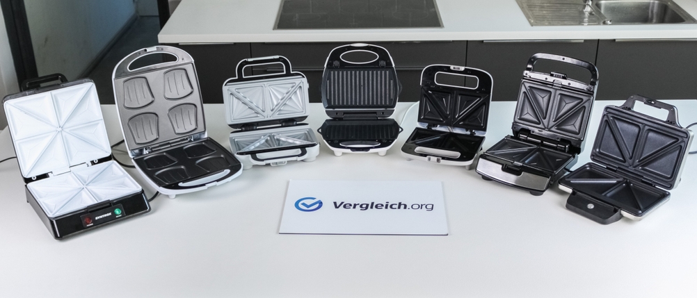 Verschiedene getestete Sandwichmaker stehen auf einer hellen Arbeitsfläche.