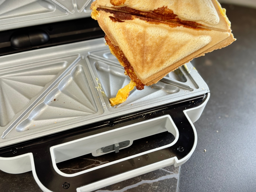 Sandwichmaker im Test: Eine Person nimmt ein Sandwich aus dem Breville-Sandwichmaker.