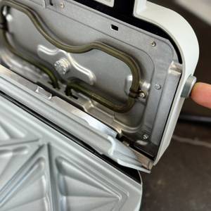 Eine Person drückt auf einen seitlichen Knopf am getesteten Sandwichmaker von Breville.