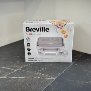 Der getestete Sandwichmaker von Breville steht verpackt auf einer dunklen Arbeitsfläche.