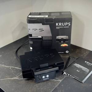Der getestete Sandwichmaker von Krups steht mit der Verpackung auf einer Arbeitsfläche.