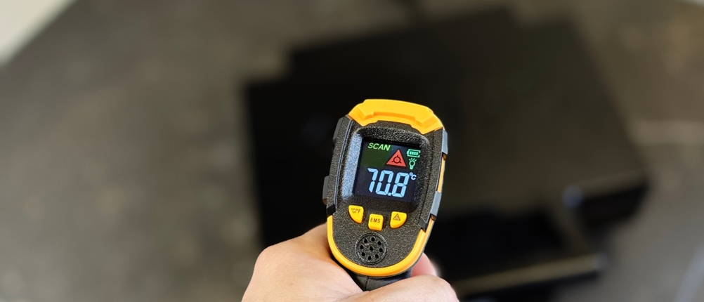 Eine Person misst mit einem Laser-Thermometer die Außentemperatur des getesteten Sandwichmakers von Krups.