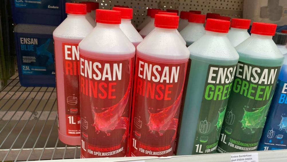 Mehrere Flaschen der getesteten Sanitärflüssigkeit stehen neben anderen Produkten in einem Verkaufsregal.