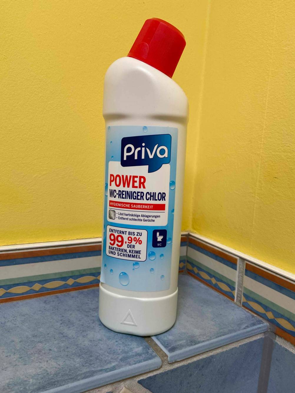 Die getestete Sanitärflüssigkeit vor einer gelben Wand.