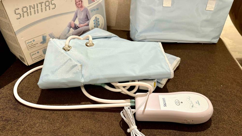 Getestetes Venen-Massagegerät liegt auf einem dunklem Untergrund.