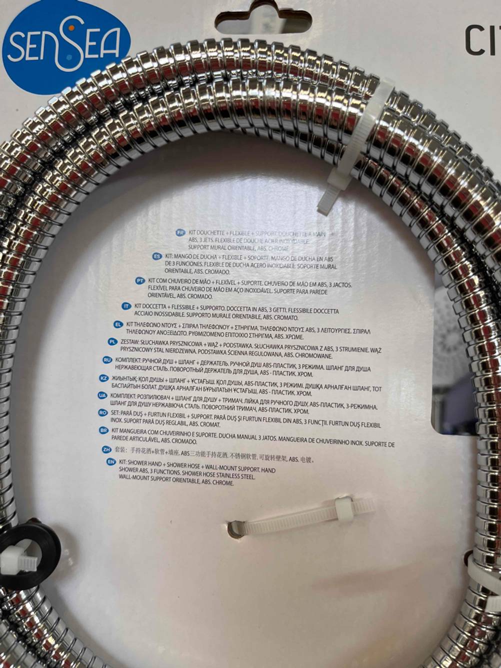 Regenduschkopf im Test. Die Beschreibung ist in mehreren Sprachen auf der Rückseite eines verpackten Schlauchs zu lesen.