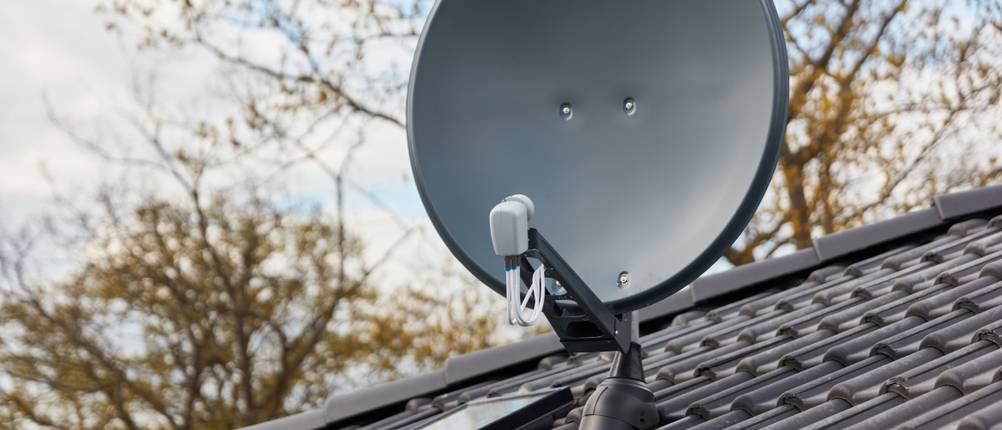 Satellitenschüssel-Test: Eine grauem moderne Satellitenschüssel auf einem Dach.