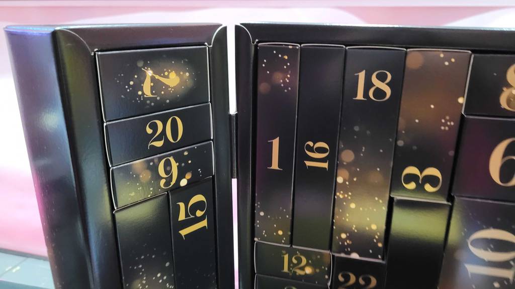 Erotik-Adventskalender im Test: Nahaufnahme eines schwarzen Kalenders mit goldenen Ziffern.