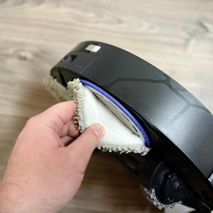 Eine Hand löst die Reinigungsaufsätze vom Gerät.