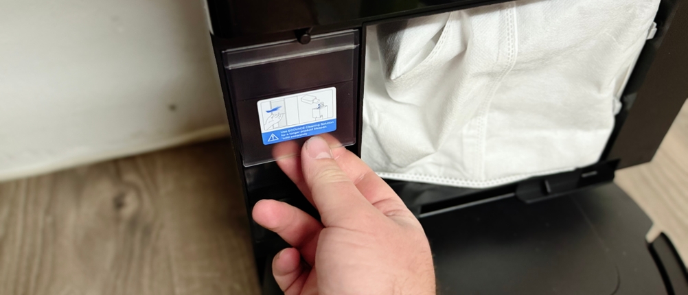 Eine Hand bedient das Display des Reinigungsmitteltank.