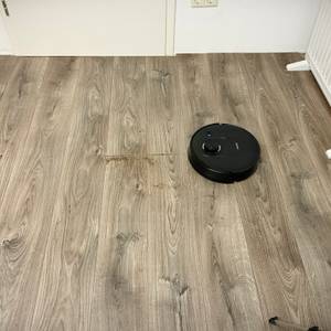 Der Saug-Wisch-Roboter fährt über das Laminat.