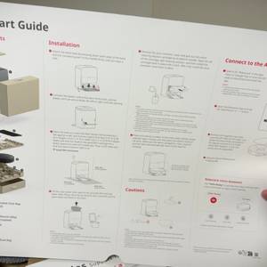 Eine Hand hält die Quick-Start-Anleitung-fest.