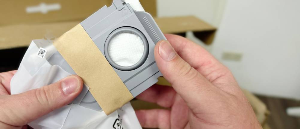 Zwei Hände halten den Filter des Saug-Wisch-Roboters.