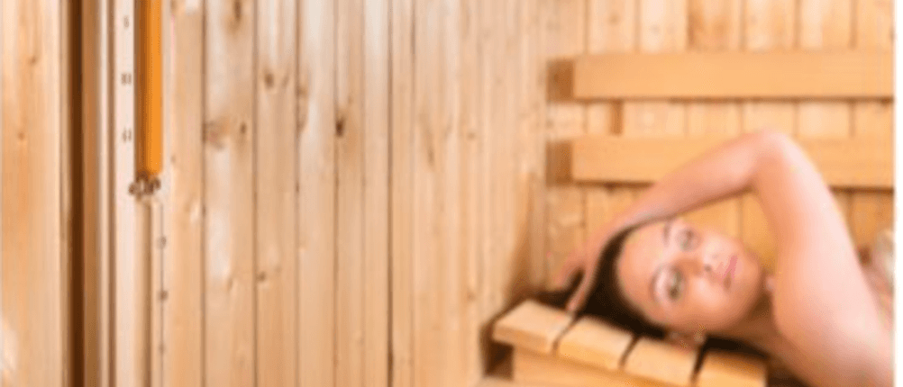 Sauna-Kopfstütze im Test: Eine Frau liegt in der Sauna auf einer schlichten Kopfstütze.
