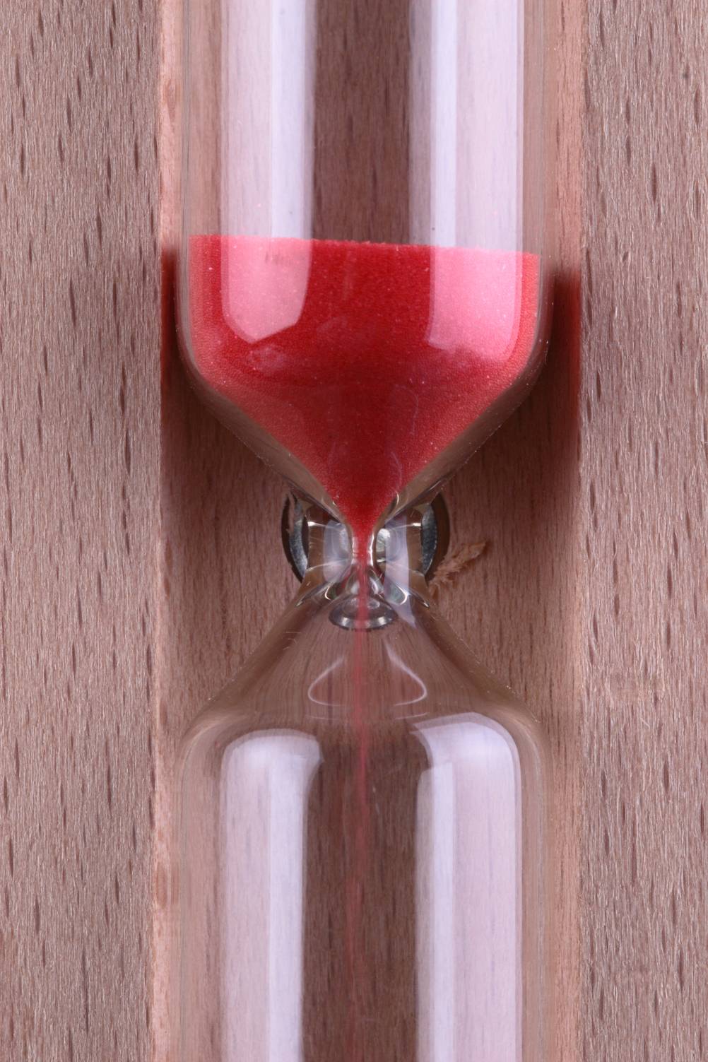 Sauna-Sanduhr im Test: Eine Nahaufnahme in die Mitte einer Holz-Sanduhr mit rotem Sand.