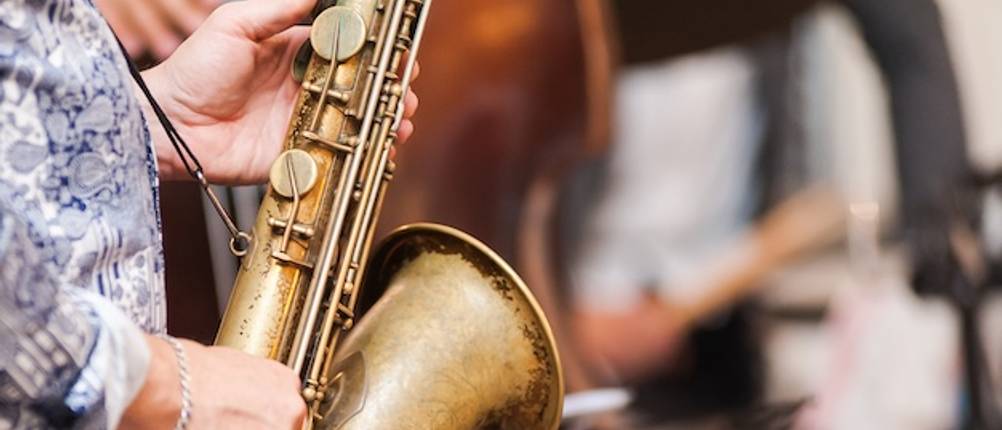 Ein getesteter schmaler Saxophongurt trägt ein schweres Saxophon in einer Jazzband.