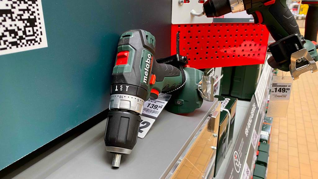 Metabo-Akkuschrauber-Test: ein grün-schwarzer Schlagbohrer inklusive Preisschild lehnt auf einem Ausstellungsregal.
