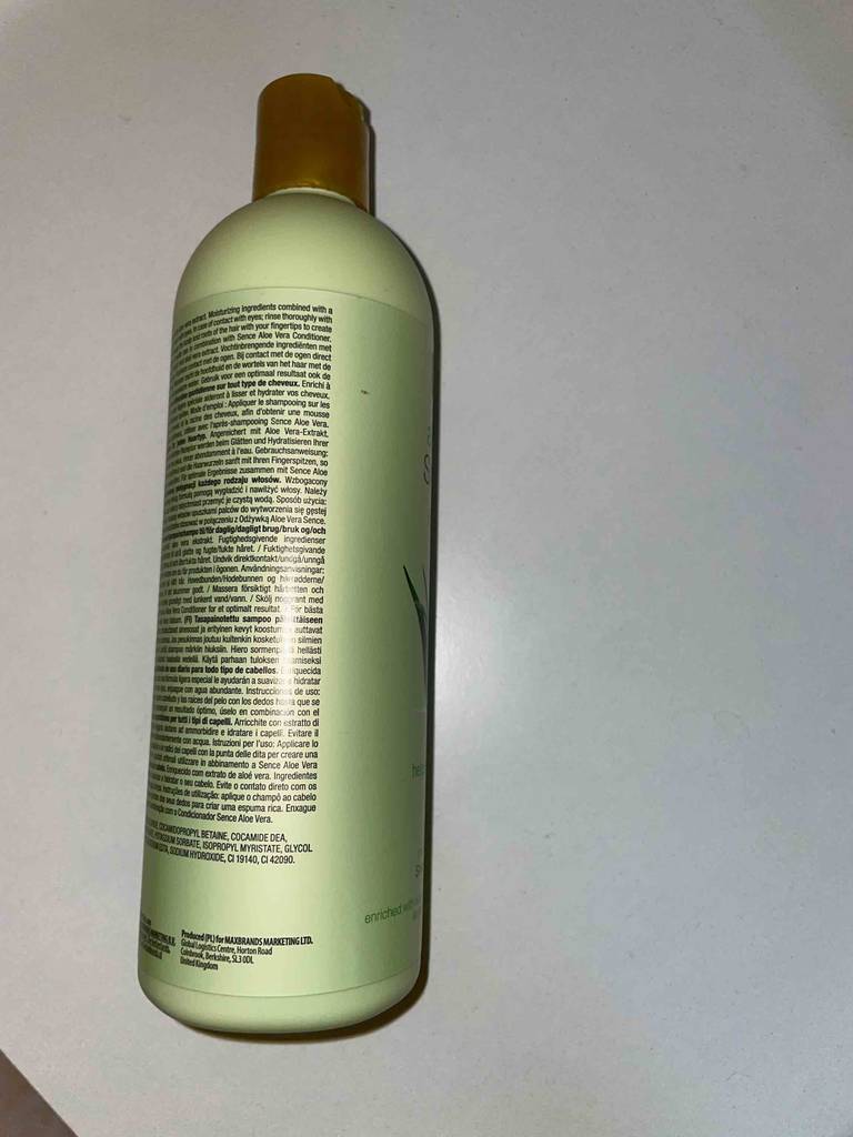 Eine Flasche des getesteten Aloe-vera-Shampoos liegt mit der Rückseite nach oben auf einer hellen Fläche.