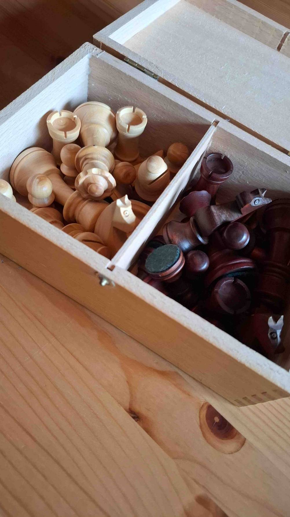 Im Test: Detailansicht von in einer Holzkiste liegenden Schachfiguren.