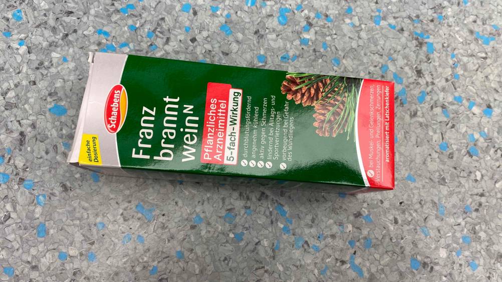 Im Test: Die Originalverpackung einer Flasche Franzbranntwein auf einer grauen Fläche horizontal.