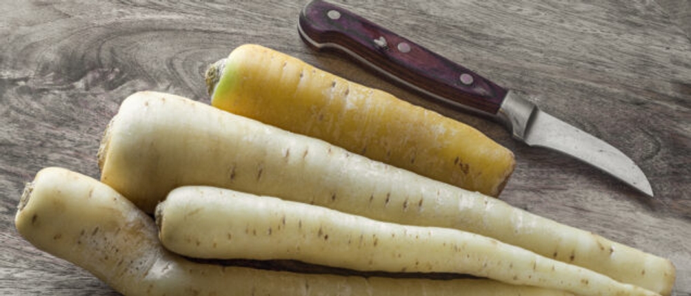 Schälmesser liegt neben Wurzelgemüse.