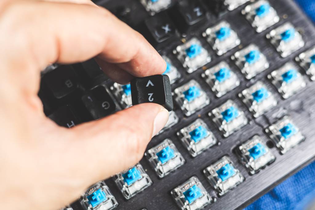 Mann tauscht einen Schalter bei einer getesteten mechanischen Tastatur aus