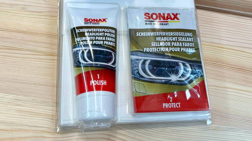 Nahaufnahme des Inhaltes eines Scheinwerfer-Aufbereitungs-Set im Test in der transparenten Originalverpackung.
