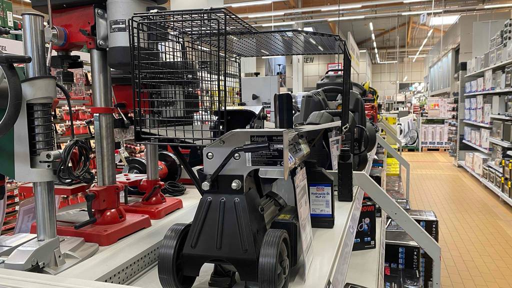 Ansicht der schmalen Seite eines im Baumarkt stehenden Holzspalters im Test, mit Fokus auf den Feststellhebel und die beiden Transporträder sowie den Schutzkäfig.