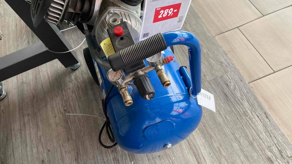 Preisschild und Druckminderer von einem getesteten Kompressor der Marke Scheppach.