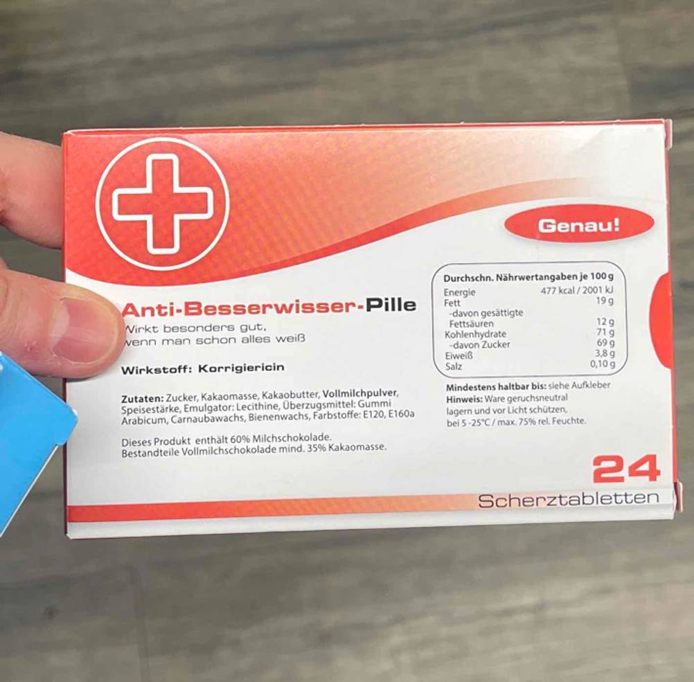 Die Rückseite der getesteten Scherztabletten von einer Hand gehalten.