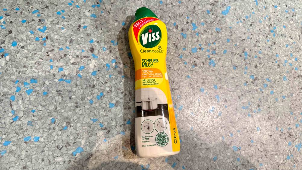 Auf einem grau-blauen Boden liegt eine Flasche der Scheuermilch im Test.