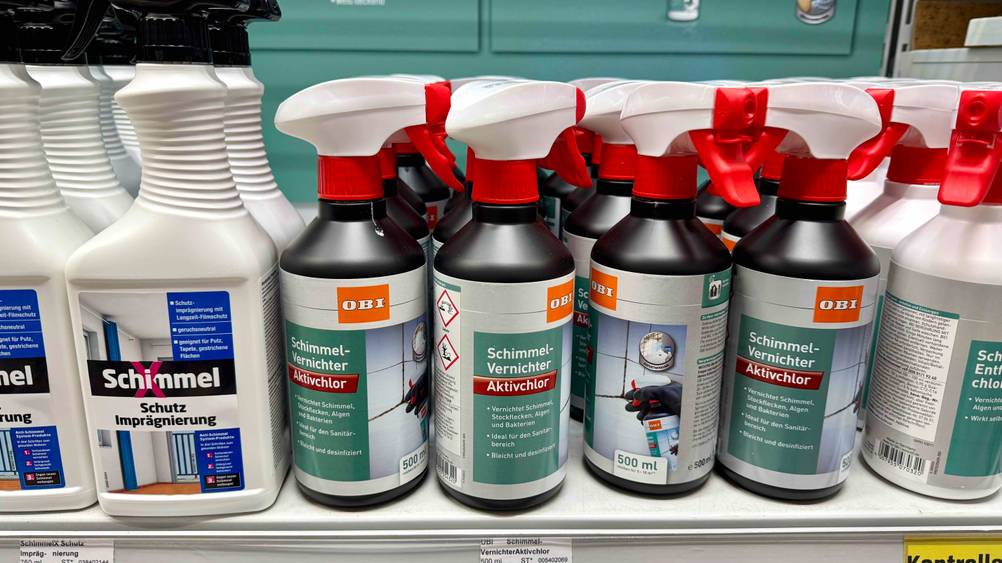 Mehrere Flaschen des Schimmelsprays im Test auf einem Verkaufsregal neben anderen Produkten.