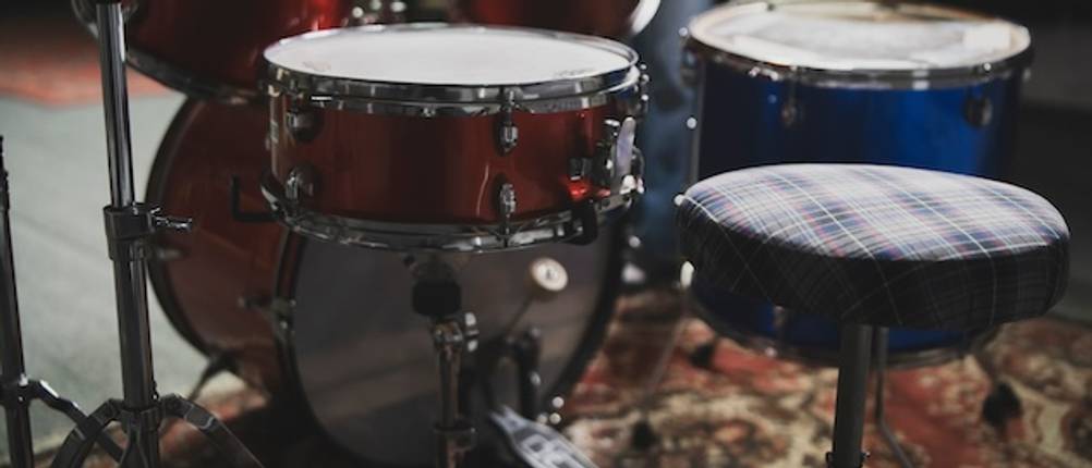 Schlagzeughocker getestet: Drumset mit einem Schlagzeughocker mit kariertem Bezug.