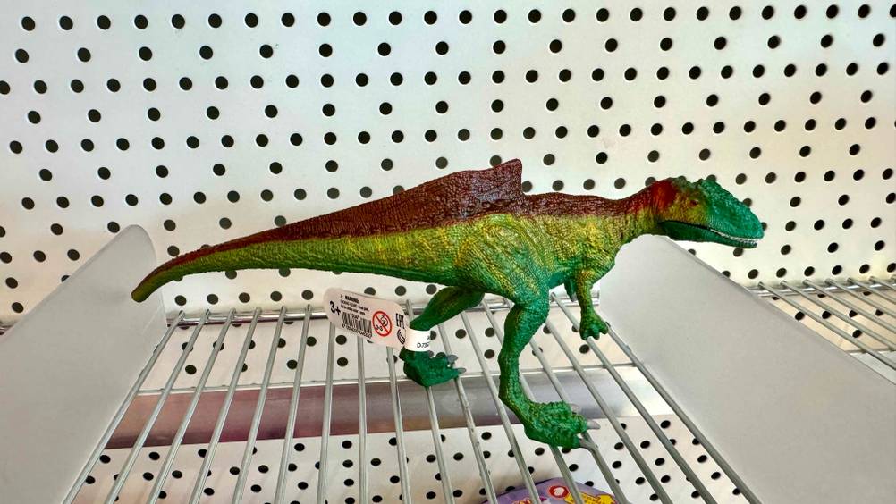Getestet: Ein Schleich-Dinosaurier von der Seite auf einem Gitter stehend.