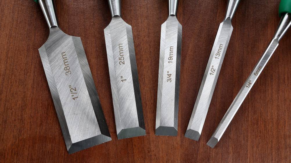 Schleifhilfe-Stechbeitel im Test: Ein Set aus fünf Stechbeiteln unterschiedlicher Größe und ohne Mangel liegt auf einer Holzoberfläche.