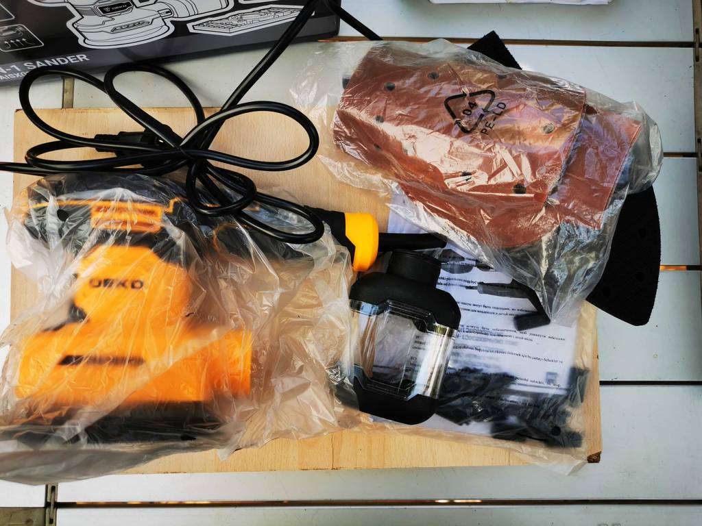 Schleifmaschine Holz im Test: Ein Set von oben betrachtet liegt auf einem Tisch.