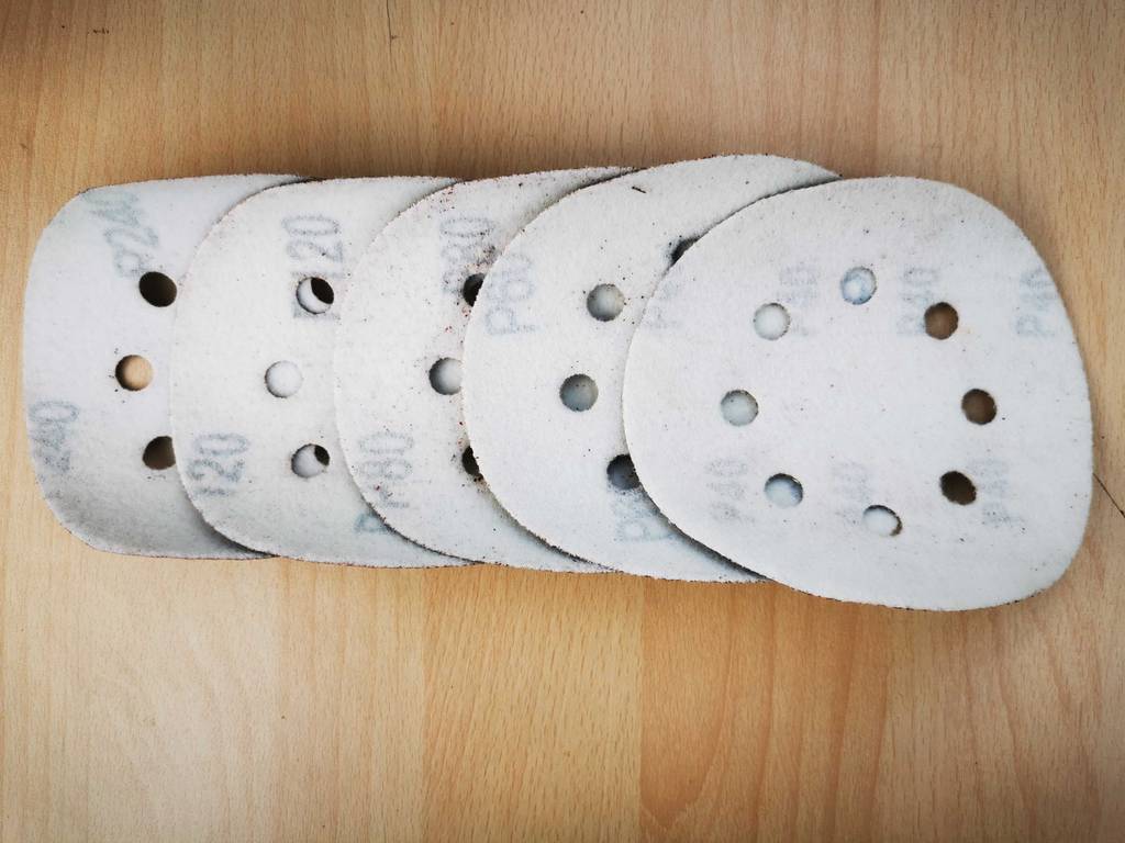Ein Satz Schleifscheiben 125 mm liegt mit der Rückseite nach oben aufgereiht.