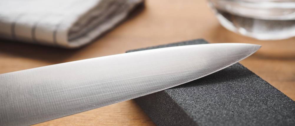 Schleifesteine im Test: Messer auf Schleifstein auf Tisch