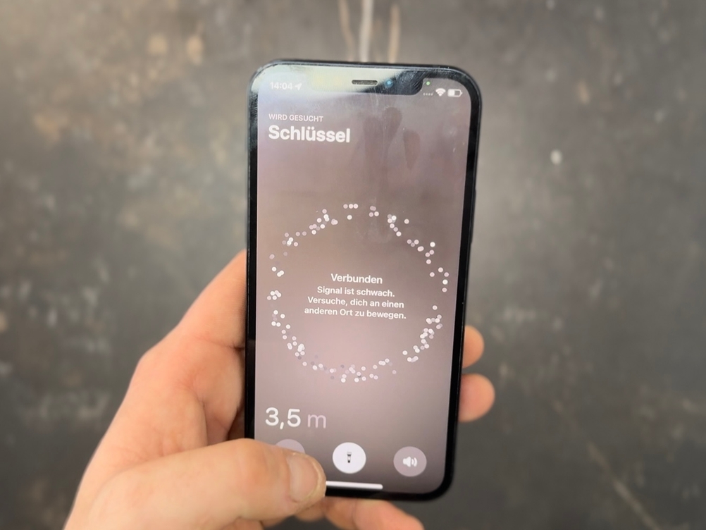Eine Person sucht mit dem iPhone den AirTag-Schlüsselfinder im Test.